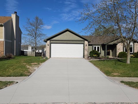 driveway replacement in Grabill. Large concrete driveway in front of a tan house.