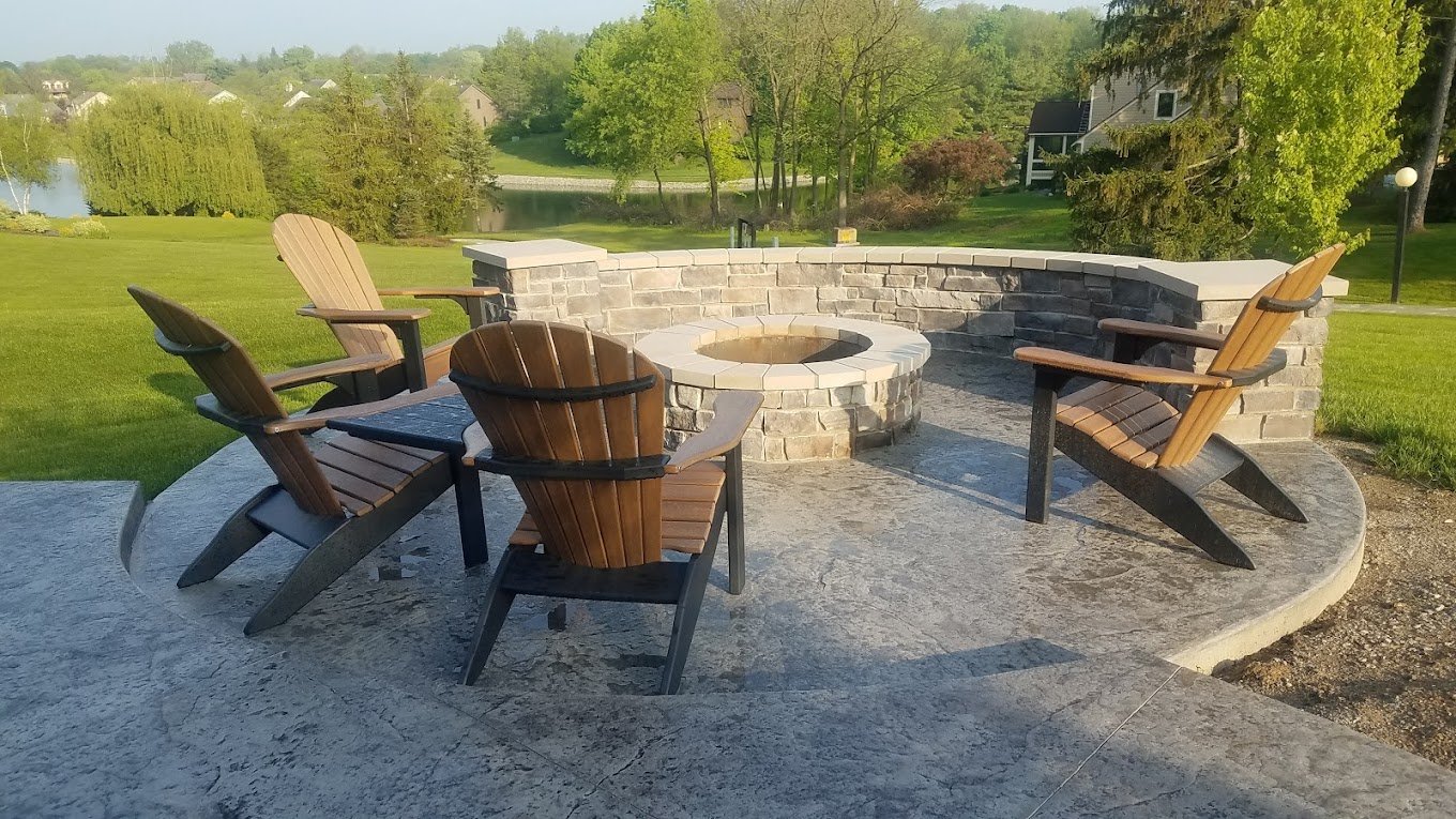 Chairs around a fire pit in a patio, that was built by Crystal Creek - the top concrete contractor in Wabash, IN. The best retaining walls in North Manchester. Concrete patios in Huntington