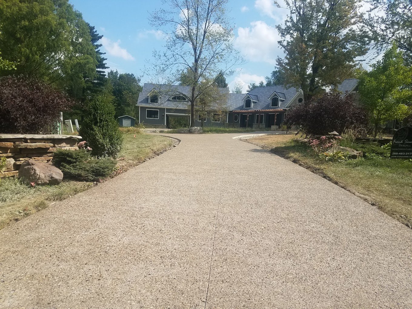 Long Tan driveway leading to a home. Showcasing the top concrete contractor in Kendallville - Crystal Creek. Driveway replacement in Berne. Driveway replacement in Waterloo