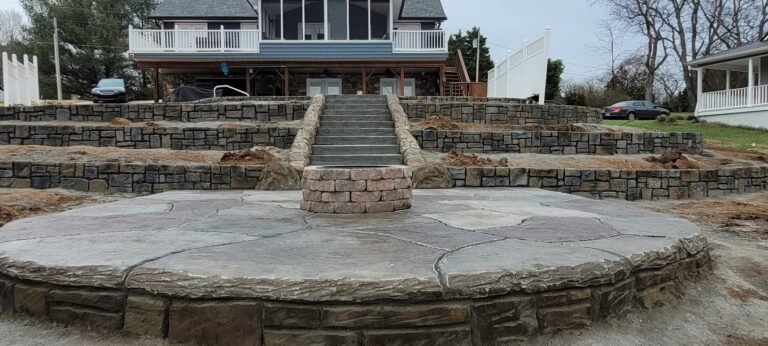 Concrete stairs leading down to a patio with a built in firepit