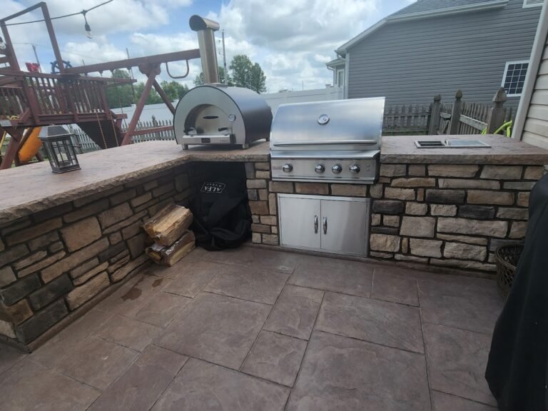 BBQ and Pizza oven integrated into a concrete retaining wall built by Crystal Creek, the trusted concrete contractor in Woodburn IN.