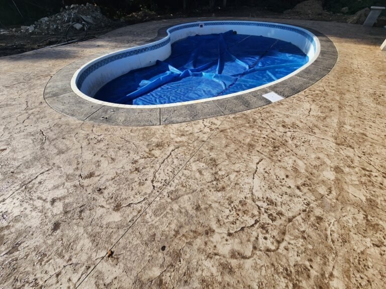 In-ground pool with a stamped pool deck around created by Crystal Creek - The premier concrete contractor in Ossian, IN.