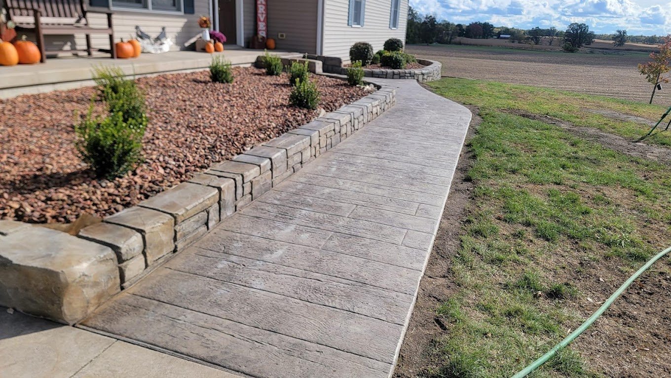 Retaining wall next to a concrete walkway. Retaining walls in Grabill.