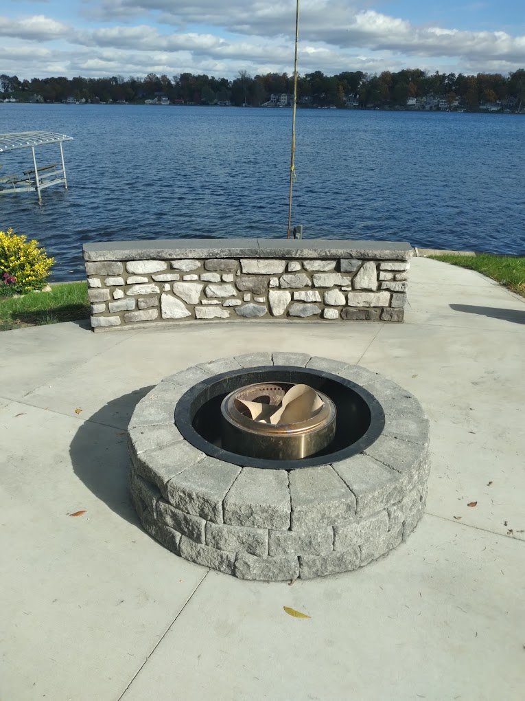 A fire pit in a patio, overlooking the lake. Showing off Crystal Creek the #1 concrete contractor in Warsaw County