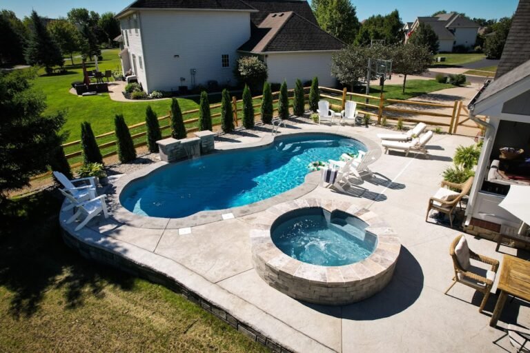 A drone shot of a patio that has a pool and hot tub installed within it. Done by Crystal Creek - the #1 concrete contractor in Warsaw, IN.