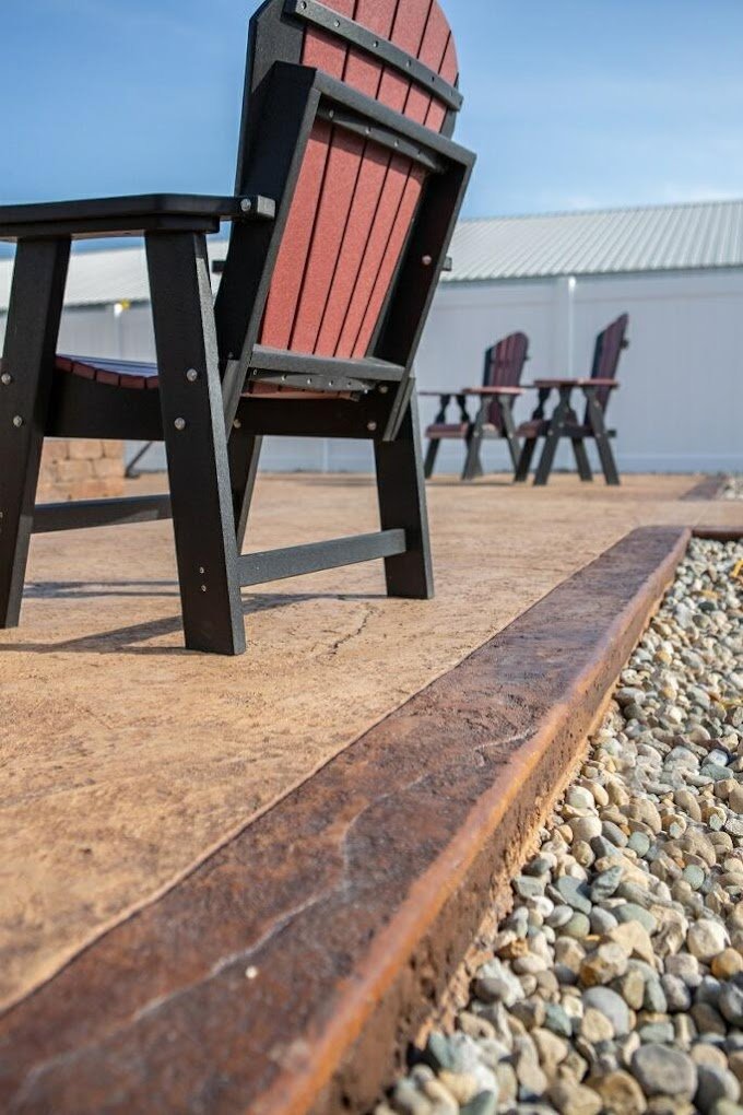 Low shot of a patio with brown curbing and a chair on it