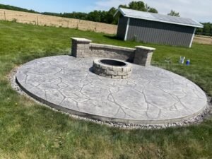 Stamped concrete patio installation in Fort Wayne Indiana with circular design and fire pit